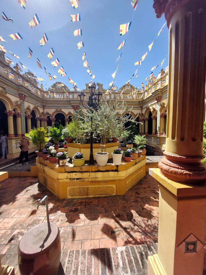 Colorful courtyard with flags and potted plants.