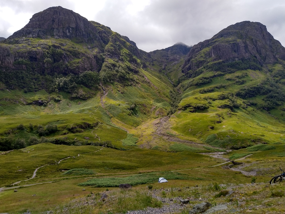 View of a lush green valley surrounded by mountains.