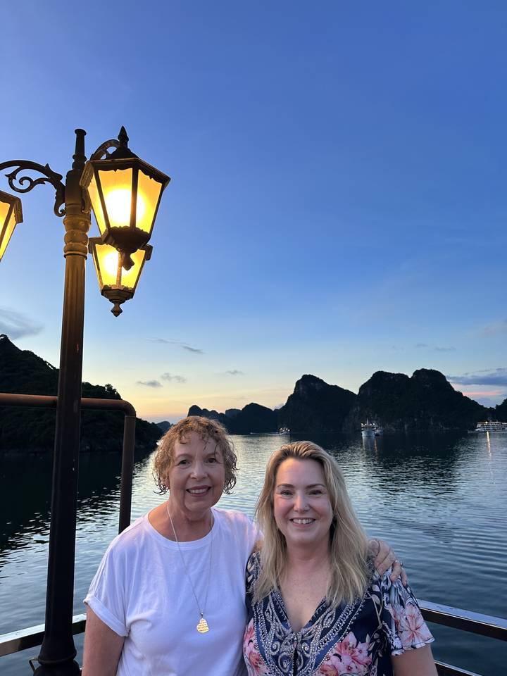 Deux femmes avec un décor d'eaux sereines et de montagnes.