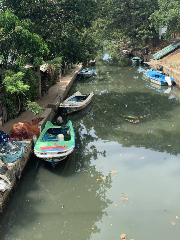 Row of small boats tied along a canal.