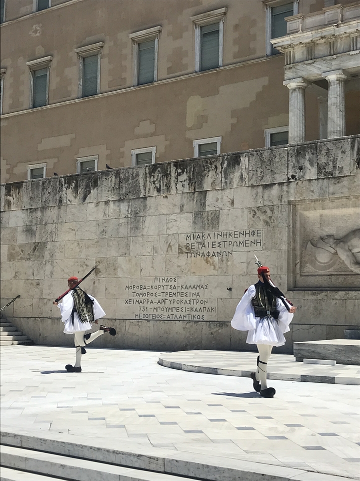 Gardes grecs traditionnels devant un bâtiment historique.