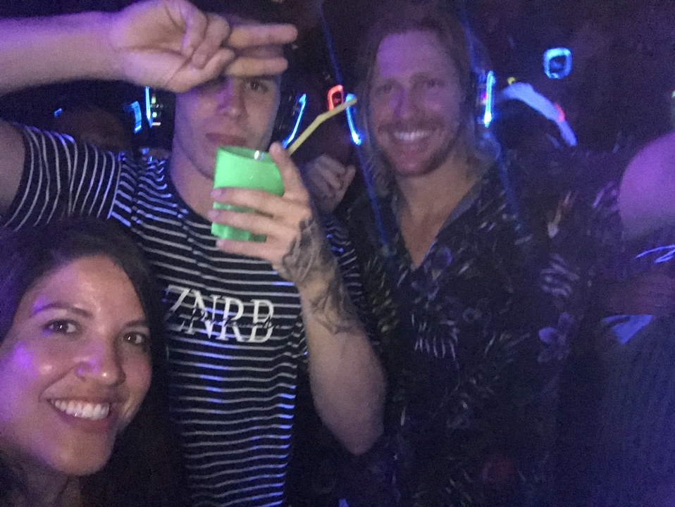 Trois personnes s'amusant à une fête faiblement éclairée.