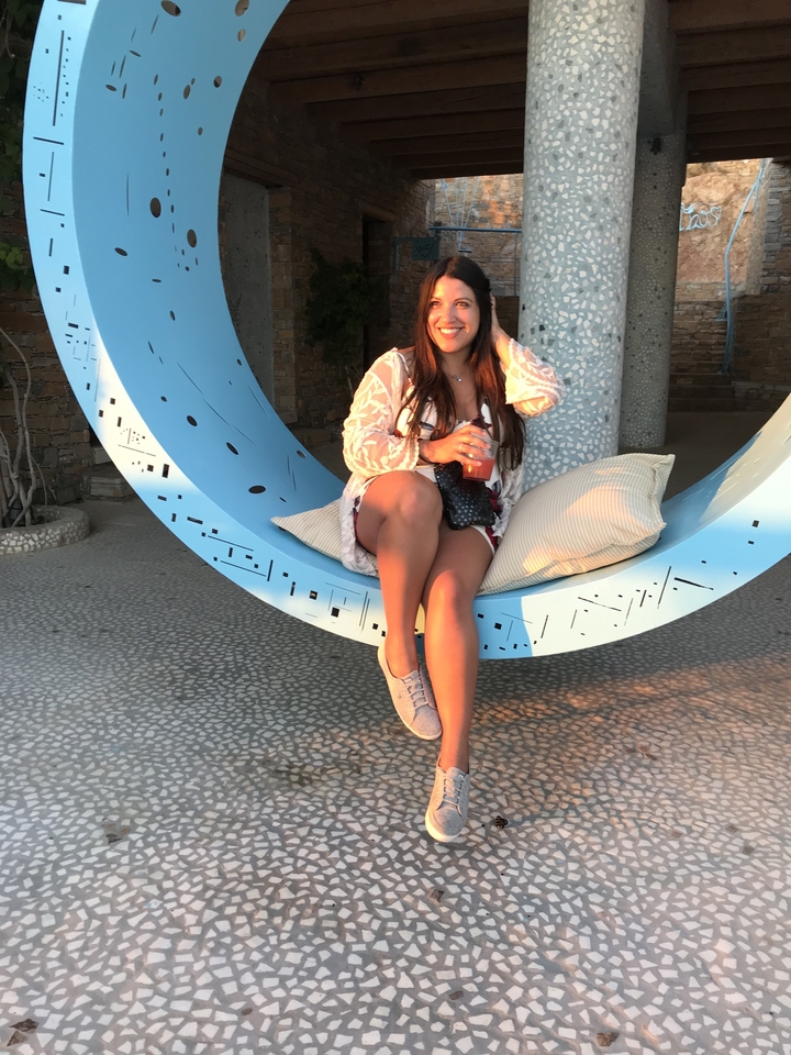Femme assise avec une boisson profitant du soleil.