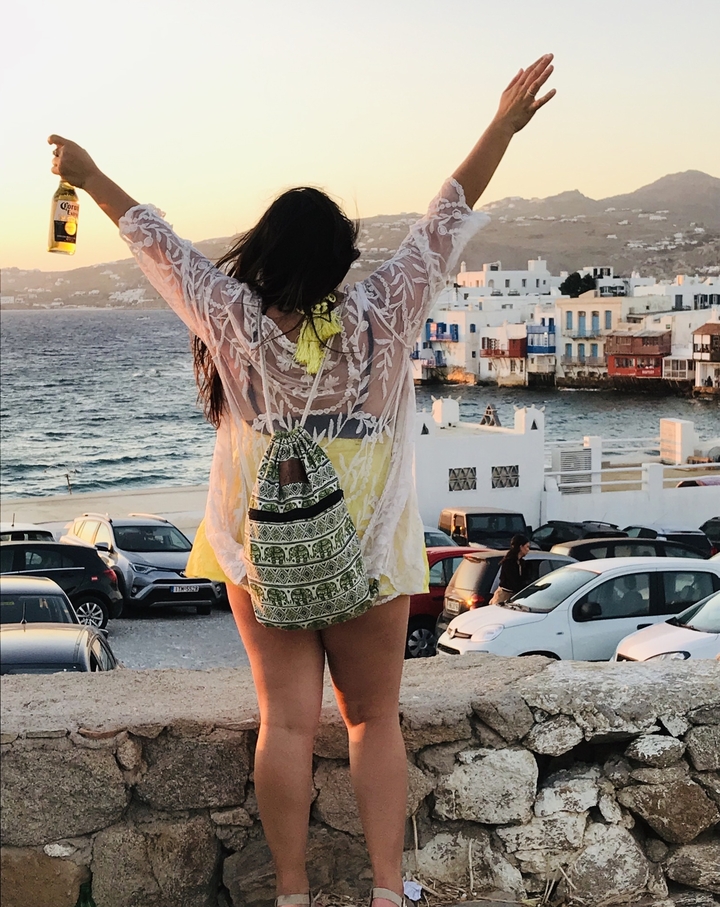 Une femme surplombant une ville côtière avec la mer.