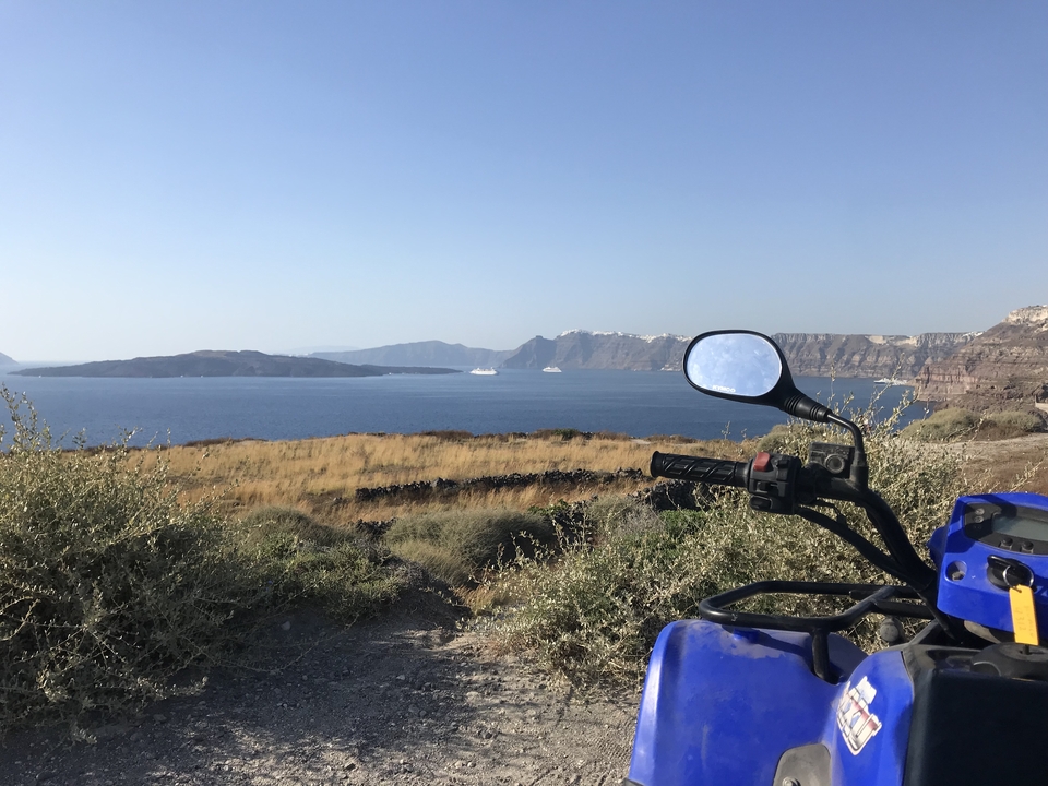 Vue panoramique sur la mer avec des îles et un véhicule d'aventure garé.