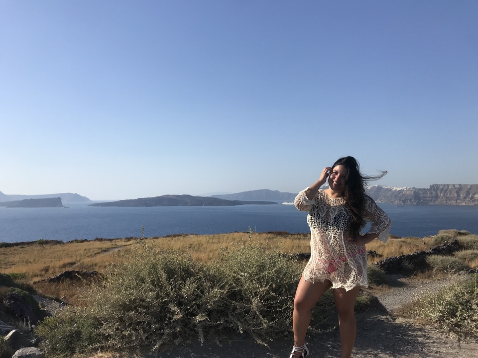 Femme posant avec une vue panoramique sur l'océan.