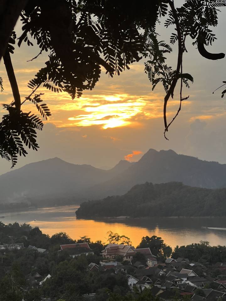 Lever ou coucher de soleil sur une rivière avec des montagnes.