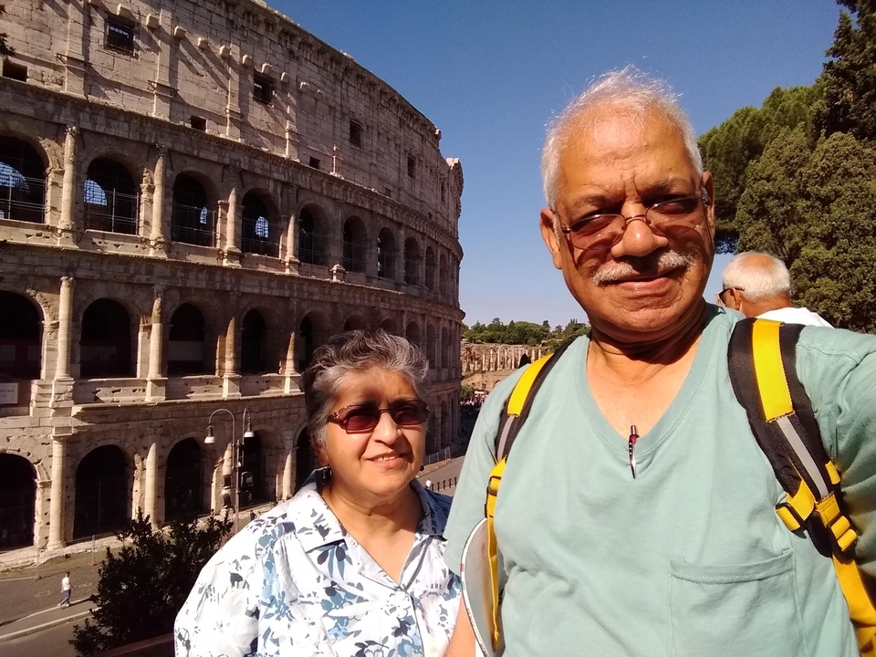 Couple taking a selfie with the Colosseum in the background.
