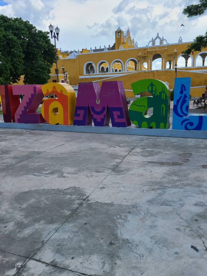 Colorful letters and yellow building facade in a public plaza.