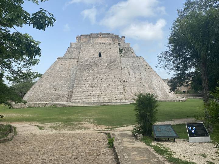 An ancient stone structure surrounded by greenery.