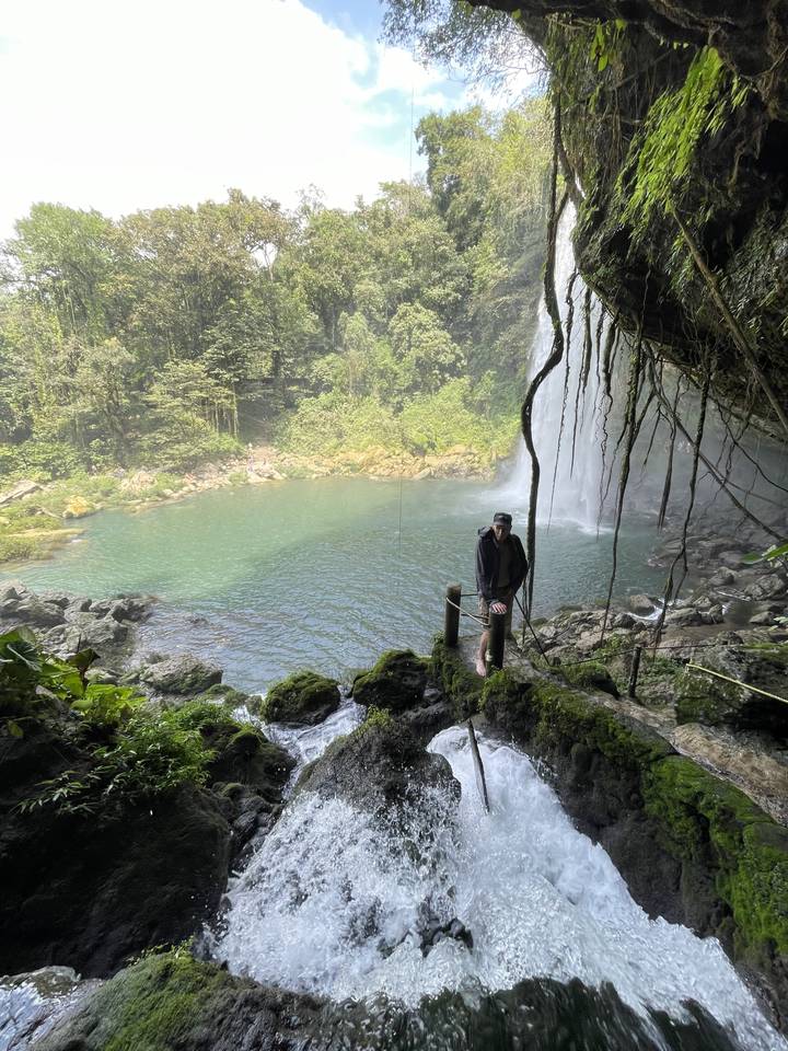 Person walking near a waterfall.