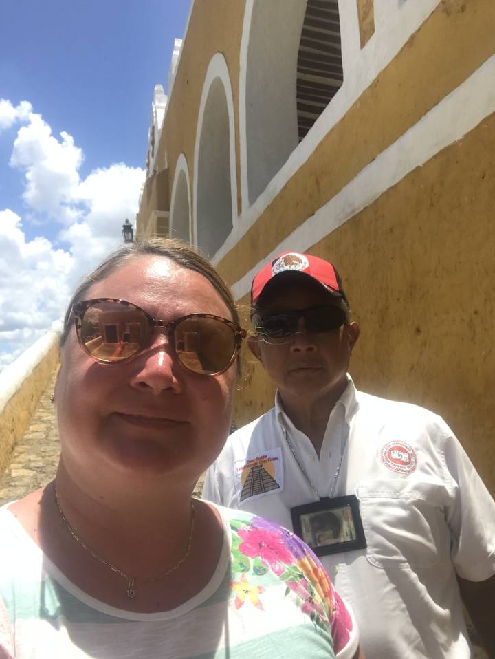 Two people posing outside a yellow building.