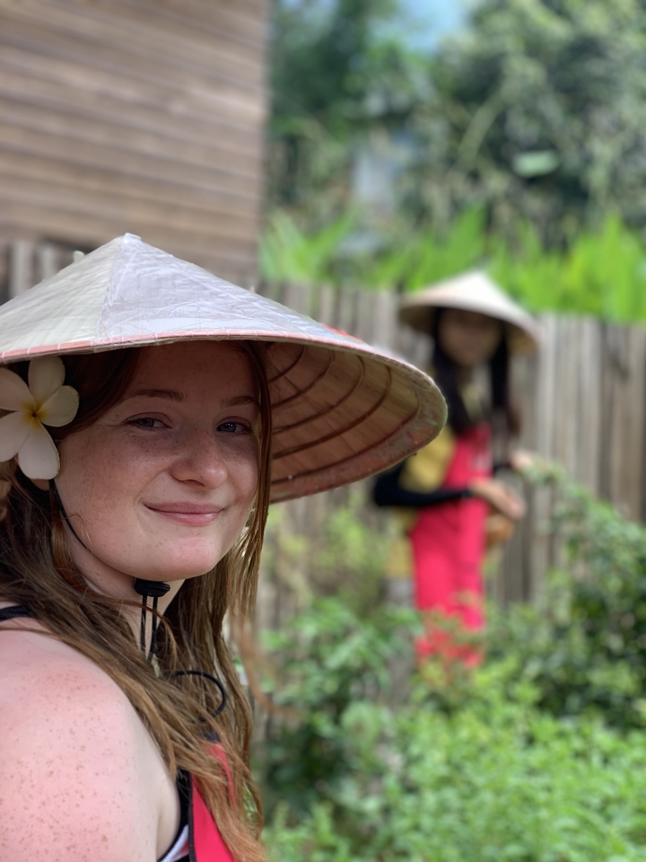 Woman in conical hat with flower in hair