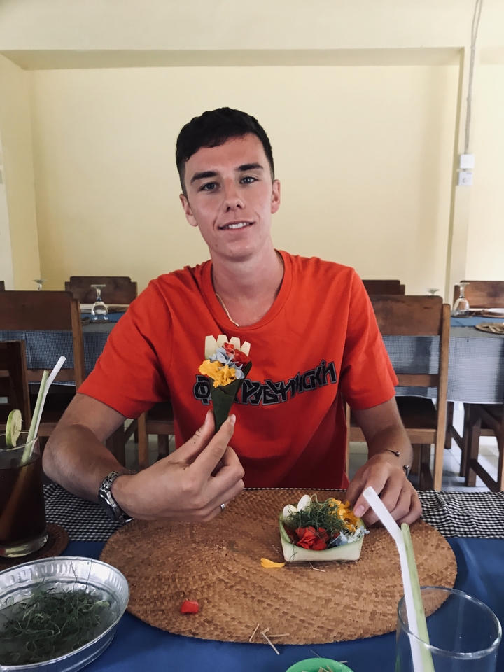 Person holding crafted offerings inside a restaurant.