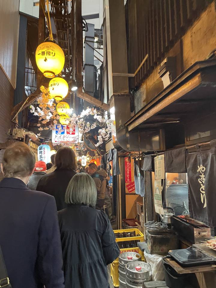 Crowded street market with lanterns and stalls.