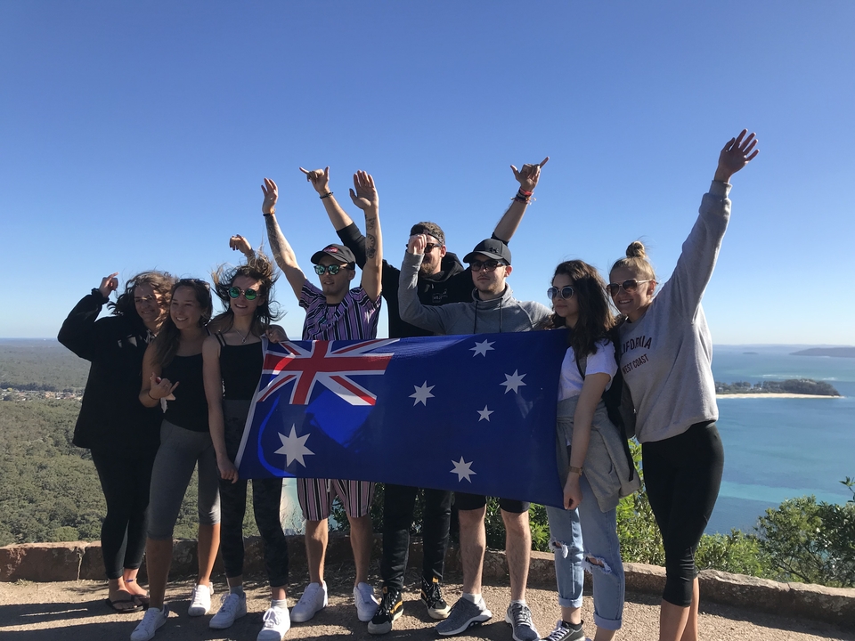 Groupe tenant un drapeau australien au sommet d'une colline.
