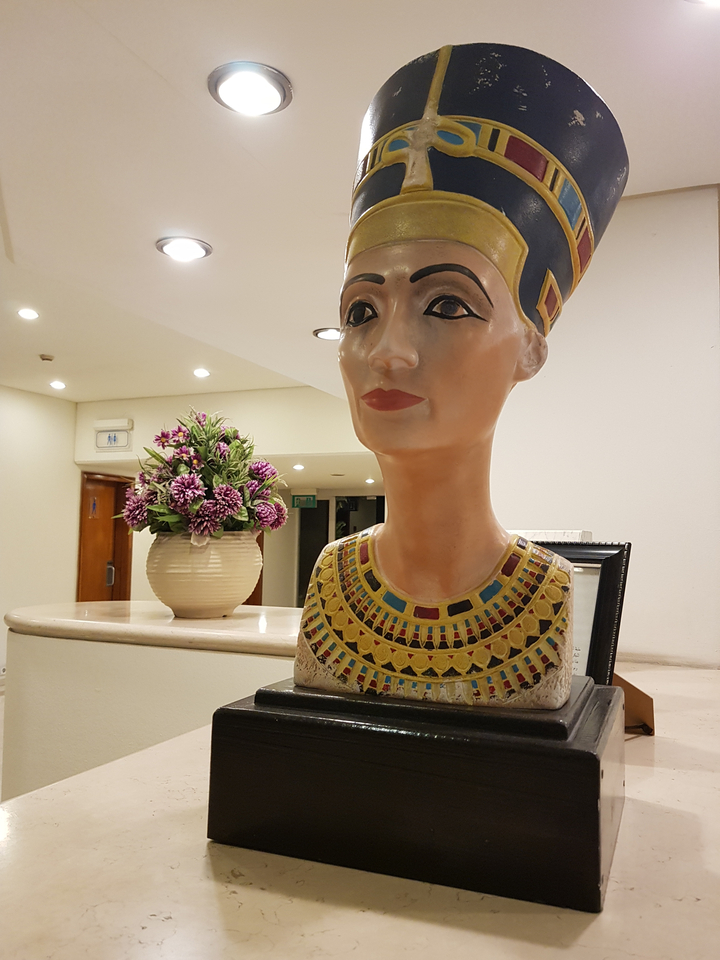 Colorful bust of an Egyptian figure in a hall.