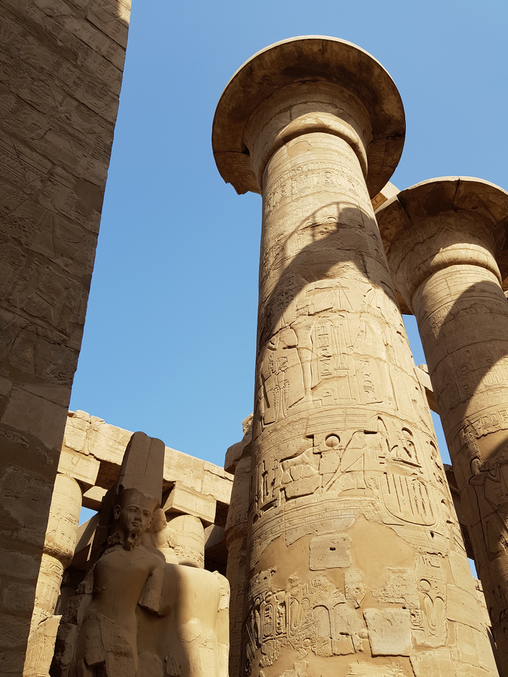 Close-up of hieroglyph-adorned columns in an ancient Egyptian temple.