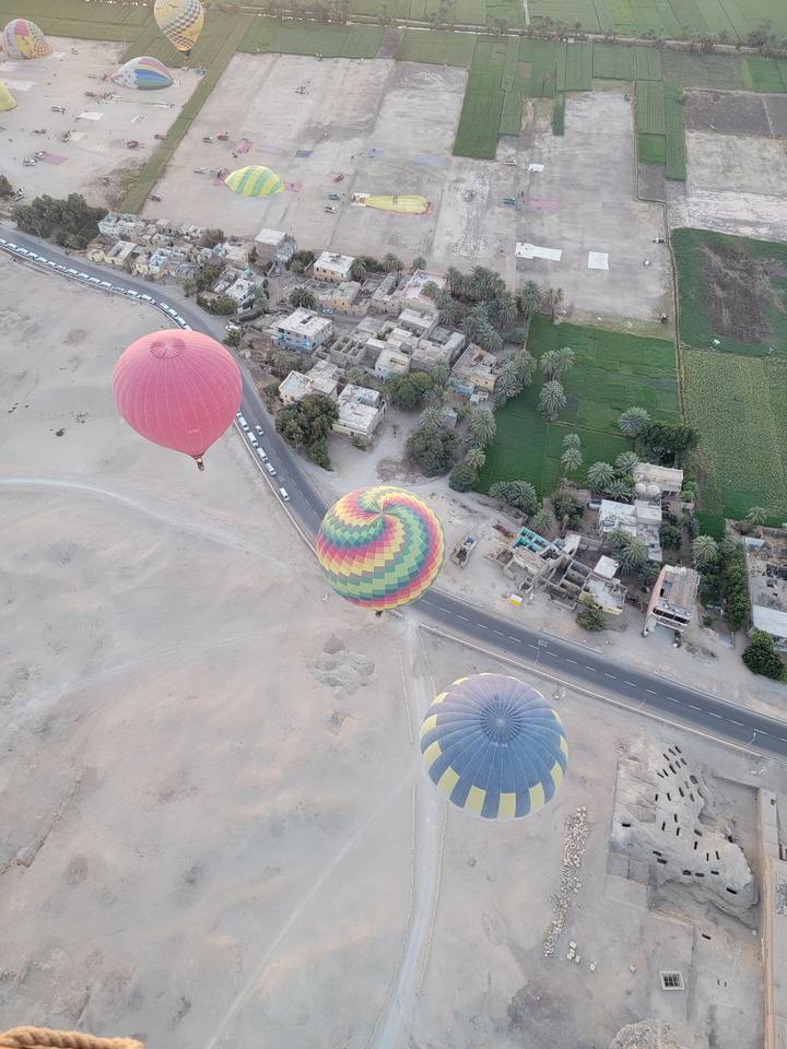 Hot air balloons over a rural landscape.