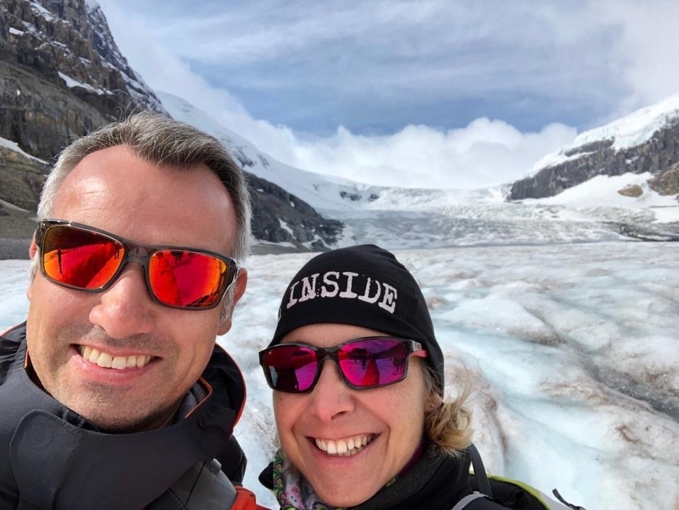 Couple smiling with a glacier in the background.