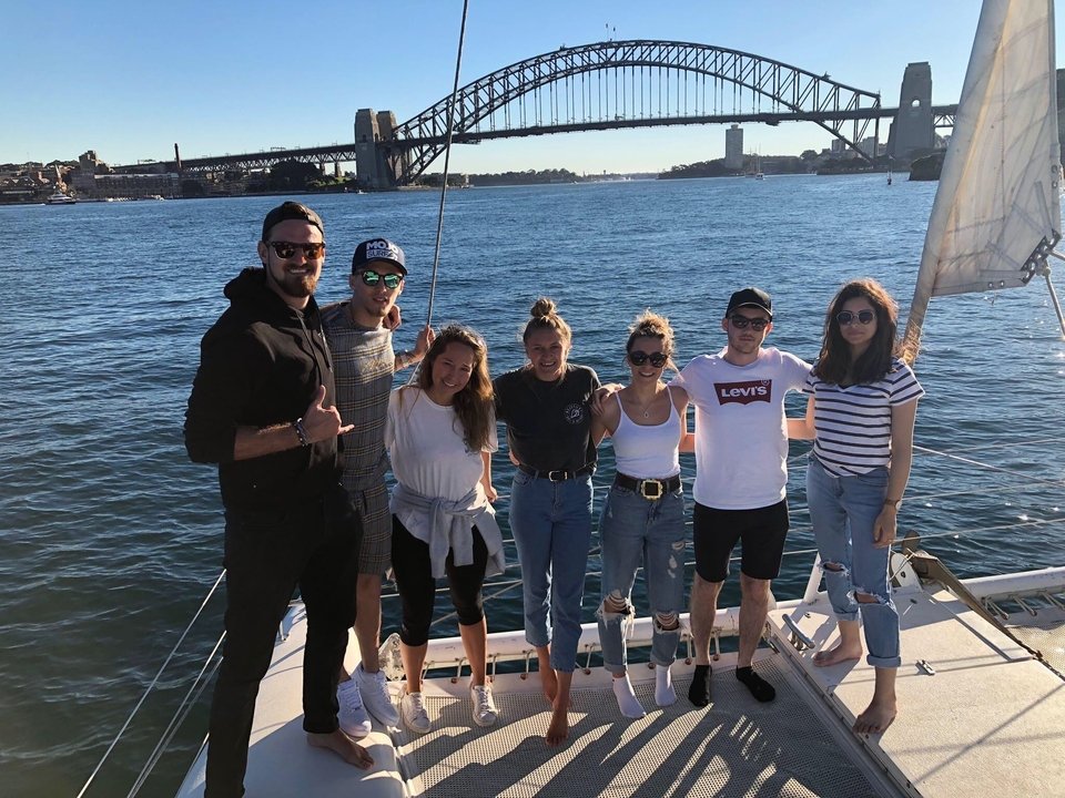 Groupe de personnes sur un bateau avec une vue sur le pont du port de Sydney.