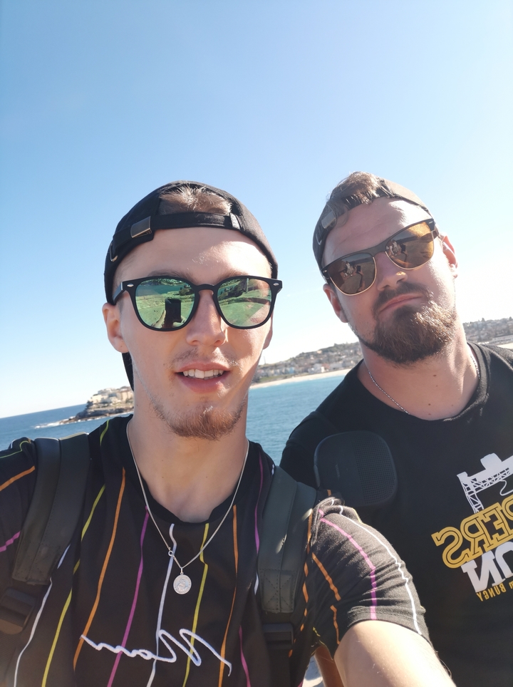 Deux personnes posant avec une vue sur l'océan derrière elles.