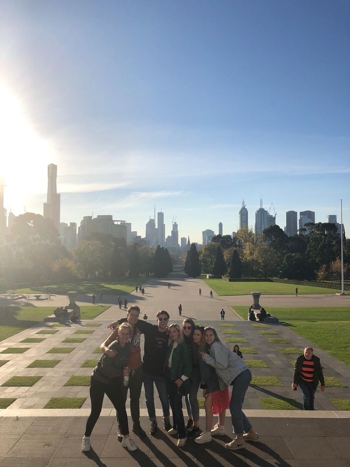 People enjoying a panoramic view of a city skyline with gardens in the foreground.