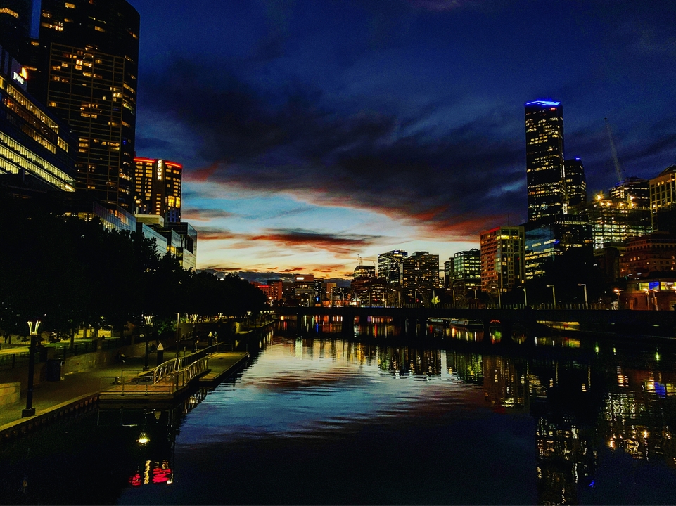 Cityscape at sunset with reflections in the river.