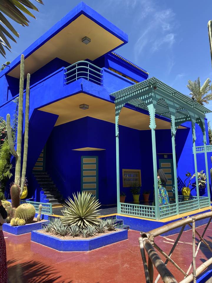 Vibrant blue building with plants and intricate details.
