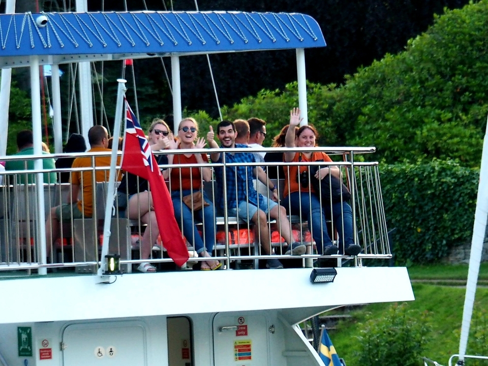 People on a boat with a flag waving.