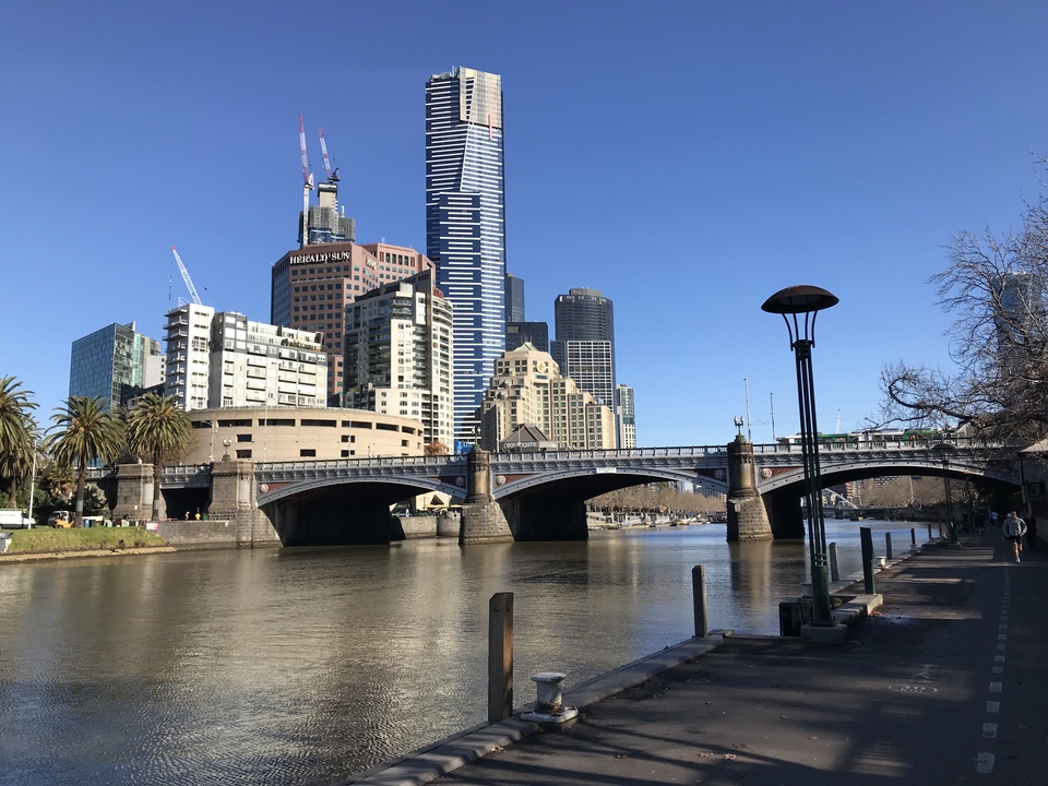 City skyline with modern high-rise buildings and a bridge over a river.