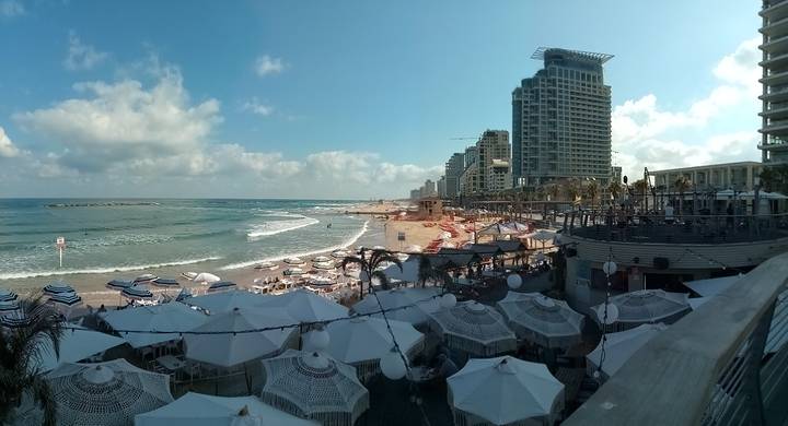 Beachfront city skyline with people on the beach.