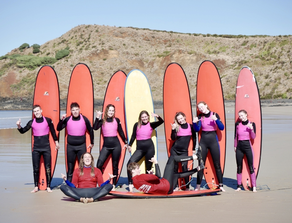 Group of people with surfboards on the beach.