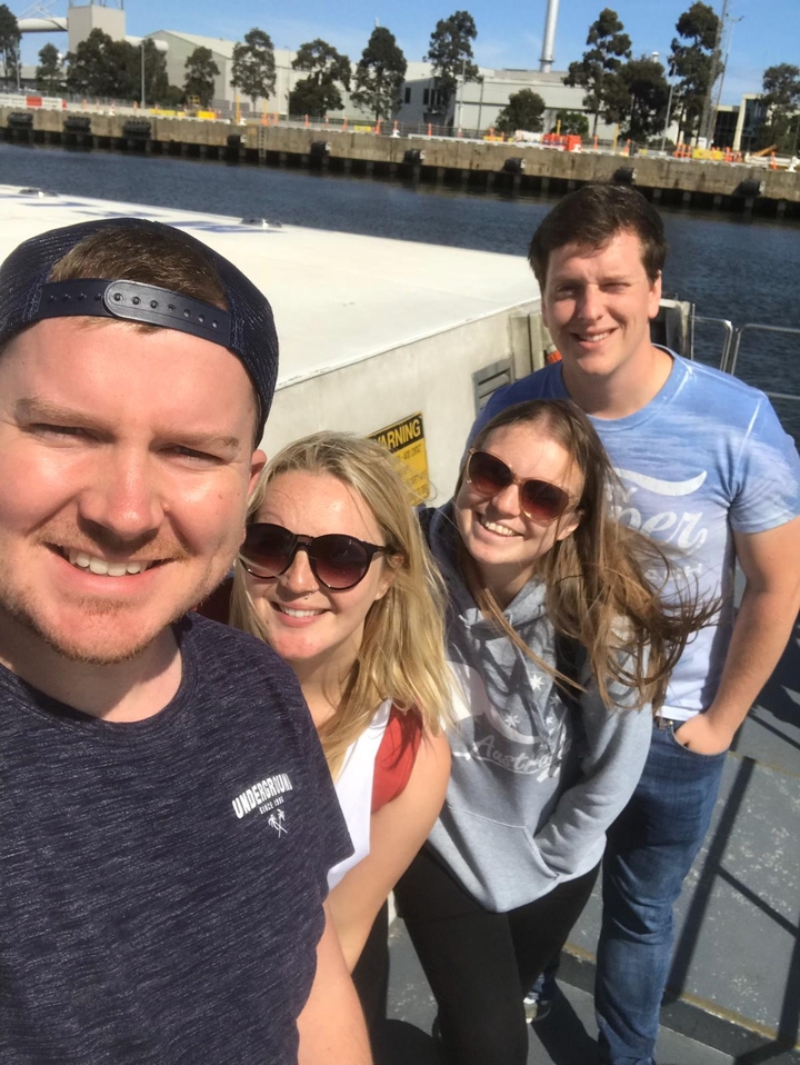Groupe de personnes souriantes sur un bateau.