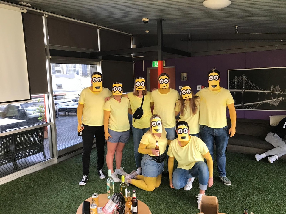 Groupe de personnes portant des costumes jaunes à l'intérieur.