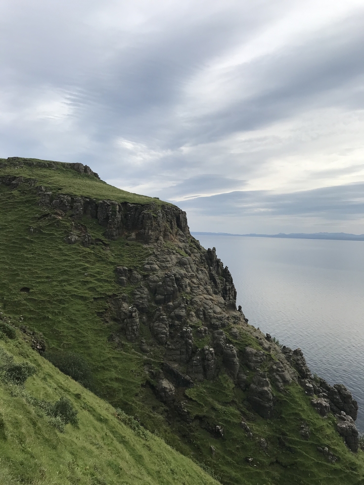 Rolling green cliffs with a view of the sea in Scotland.