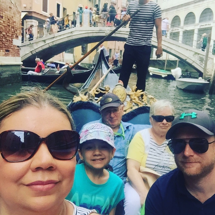Family on a gondola ride through the canals of Venice.