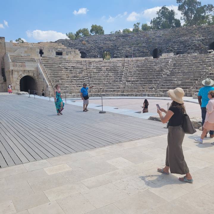 Des gens explorent un amphithéâtre antique.