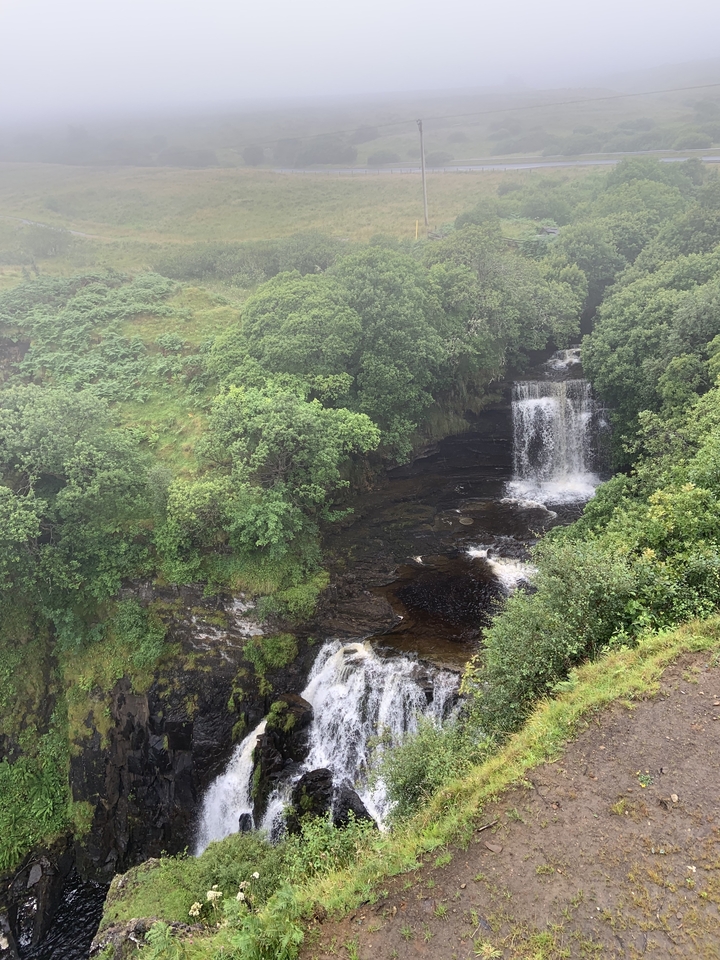 Waterfall cascading down into a lush forest area.