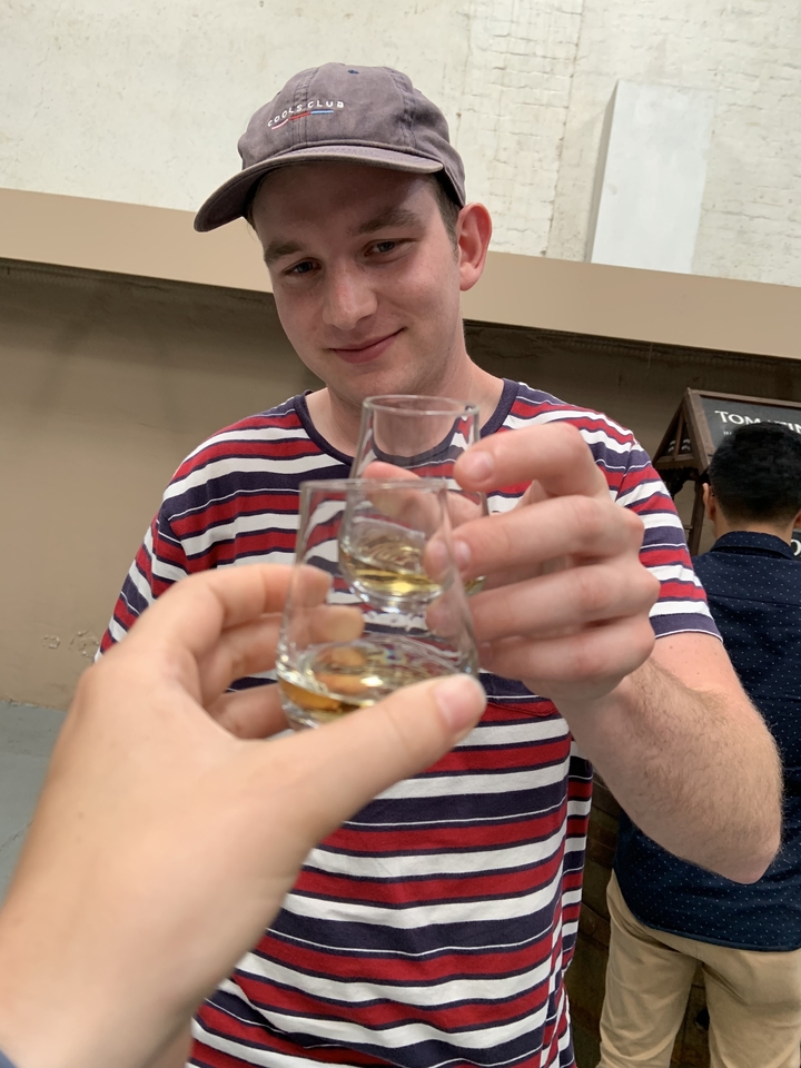 Gros plan d'une personne tenant deux verres de whisky.