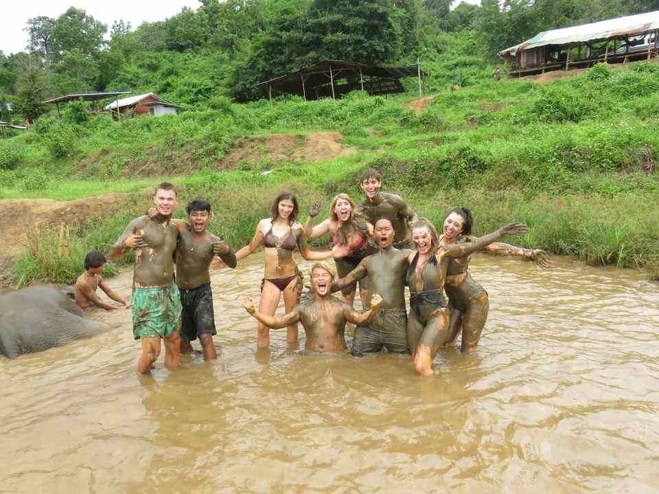 A group of people in a muddy pond having fun.