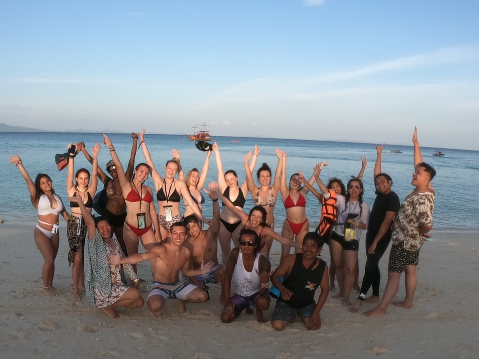 Group of people on a beach posing for a photo