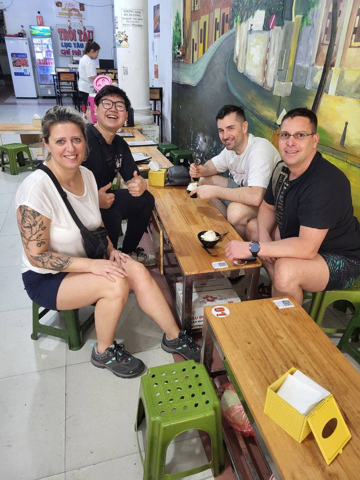 Groupe de personnes assises dans un restaurant en train de savourer leur repas.