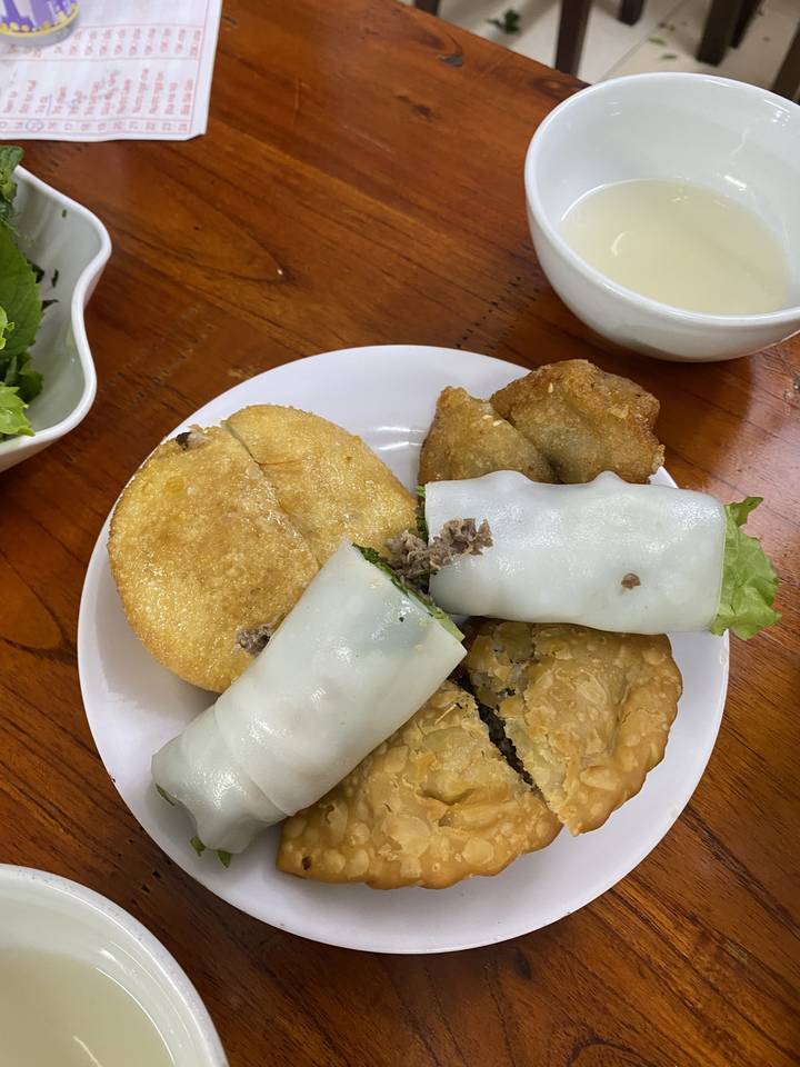 Assiette de nourriture vietnamienne assortie sur une table en bois.
