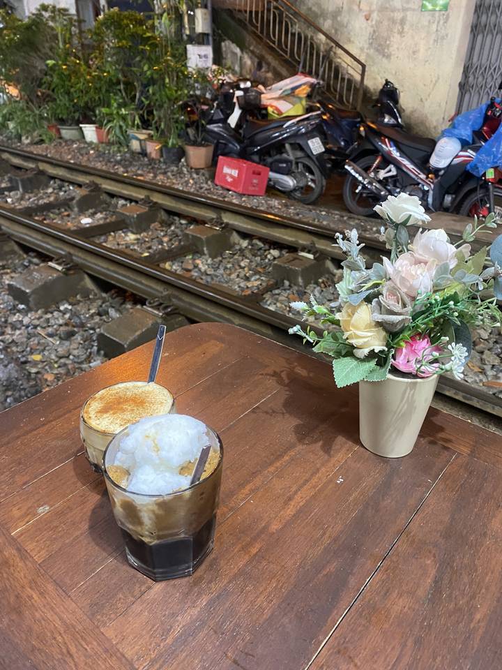 Table avec des boissons au café et des fleurs décoratives.