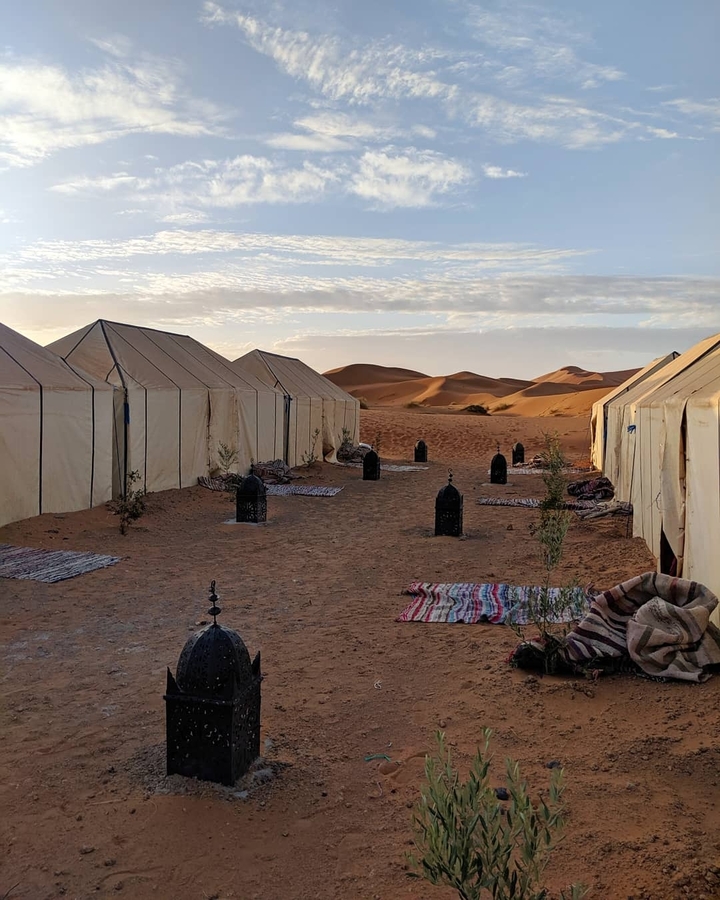 Desert camp with large tents and decorative items.