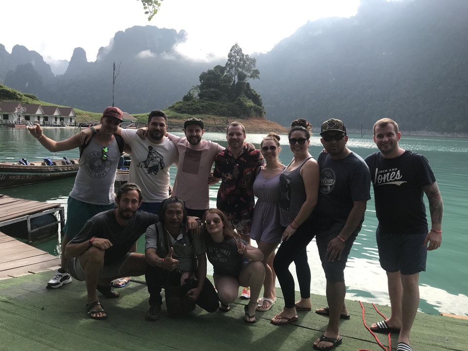 Group of people posing by a lakeside.