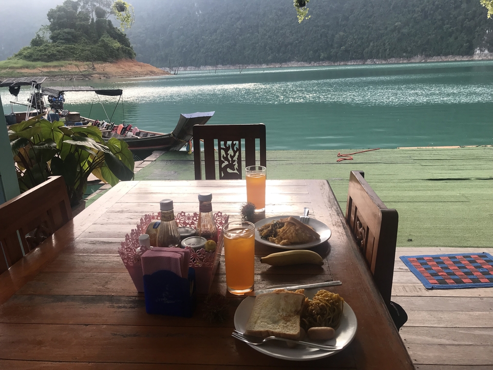 Outdoor dining setup overlooking a lake with boats.