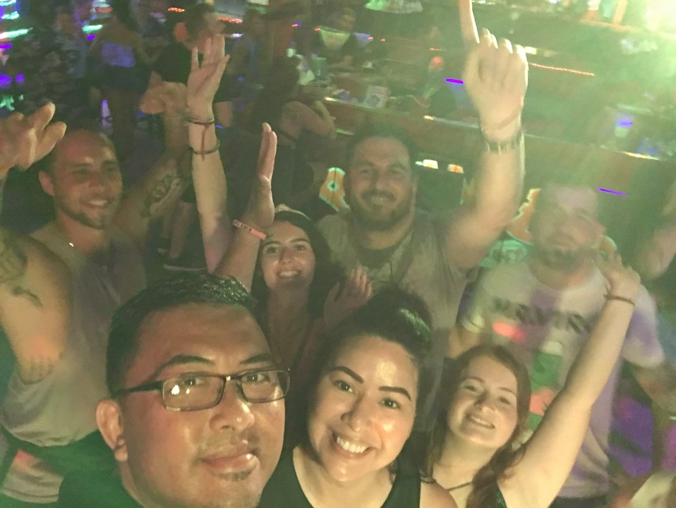 People dancing in a club with colorful lights.