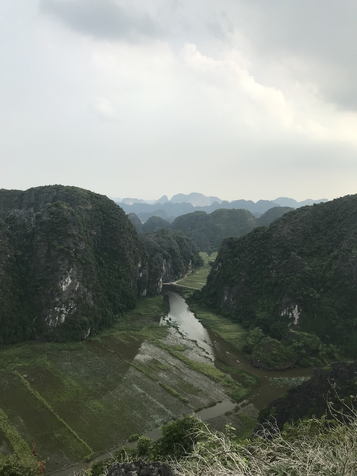 A scenic view of a river cutting through lush green mountains.